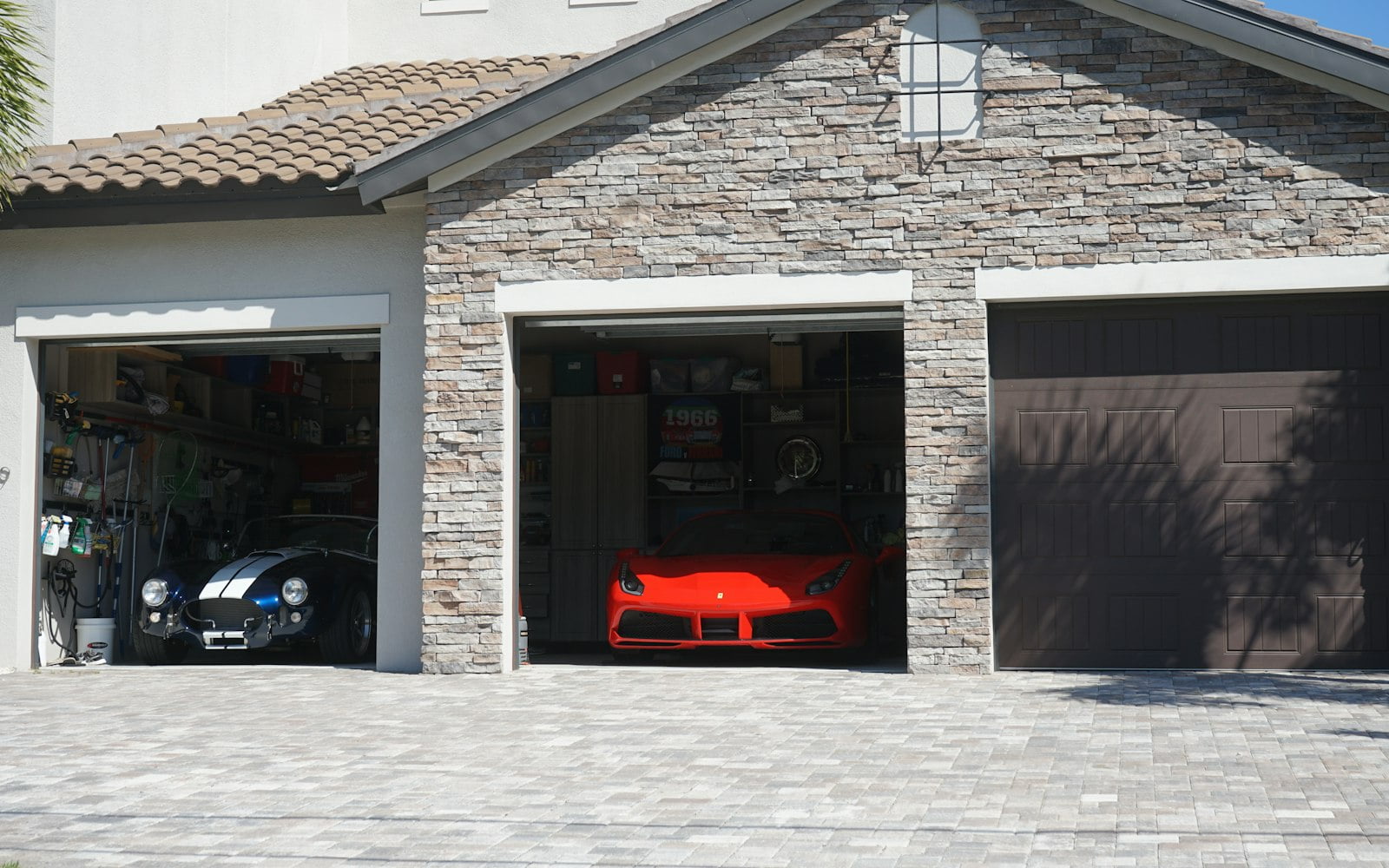 A row of garage doors on a house, two of them open onto the garages behind.